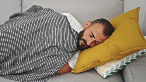 Young hispanic man lying on sofa sleeping at home Stock Footage 245021206