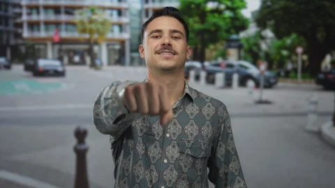 Young hispanic man with patterned shirt smiles confidently with fist gestur.. Stock Footage 307270450