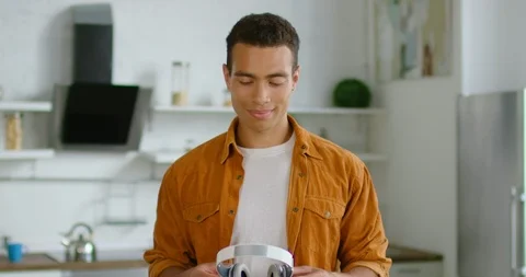 Young Hispanic man is putting wireless headset on Stock Footage 113284843