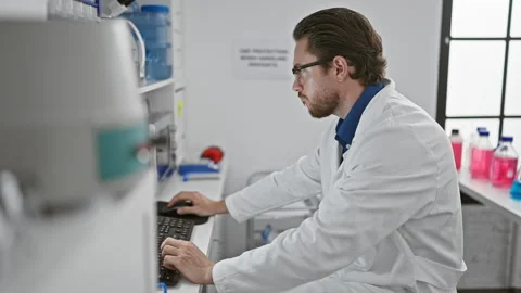 Young hispanic man scientist using computer taking glasses off stressed at .. 動画素材 249930211