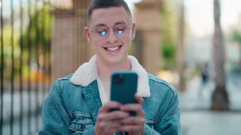 Young hispanic man smiling confident using smartphone at street Stock Footage 172053987