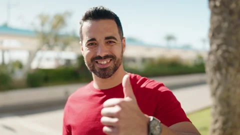 Young hispanic man smiling confident doing ok sign with thumb up at park Stock Footage 172071326