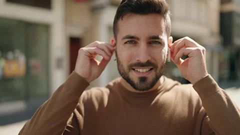 Young hispanic man smiling confident using earphones at street Video stock 180492072