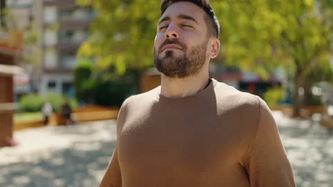 Young hispanic man smiling confident breathing at park Stock Footage 189953098