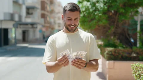 Young hispanic man smiling confident counting dollars at street Video stock 206676733
