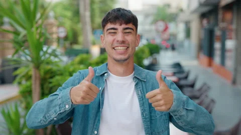 Young hispanic man smiling confident doing ok sign with thumbs up at street Stock Footage 219229541