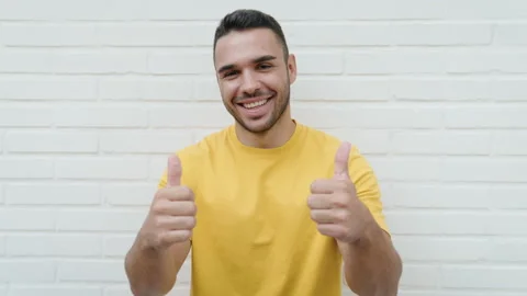 Young hispanic man smiling confident doing ok sign with thumbs up over isolat Video stock 220152010