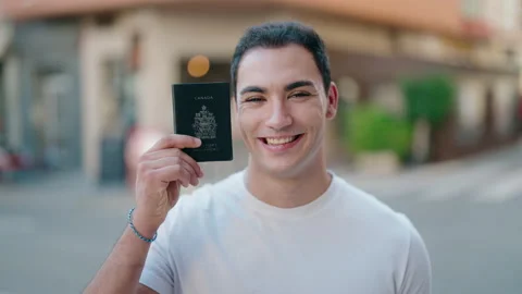 Young hispanic man smiling confident holding canada passport at street Video stock 221690886