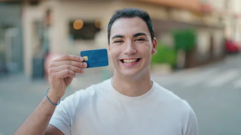 Young hispanic man smiling confident holding credit card at street Video stock 230023965