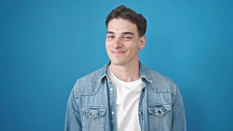 Young hispanic man smiling confident saying yes with head over isolated blu.. Stock Footage 243481243