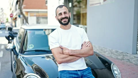 Young hispanic man smiling confident sitting on car with arms crossed gestu.. Video stock 245019986