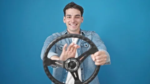 Young hispanic man smiling confident using steering wheel as a driver over .. Video stock 246123203