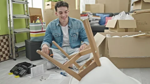 Young hispanic man smiling confident drilling chair at new home Video stock 246123426