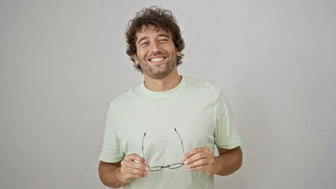 Young hispanic man smiling confident taking glasses off over isolated white.. Stock Footage 246131861