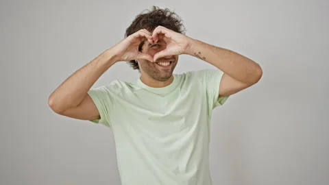 Young hispanic man smiling confident doing heart gesture with hands over is.. Stock Footage 247379094