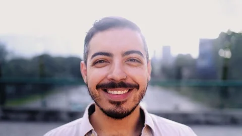 Young hispanic man smiling front of camera in the city Video stock 339749785