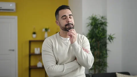 Young hispanic man standing with doubt expression and arms crossed gesture .. Video stock 232876104