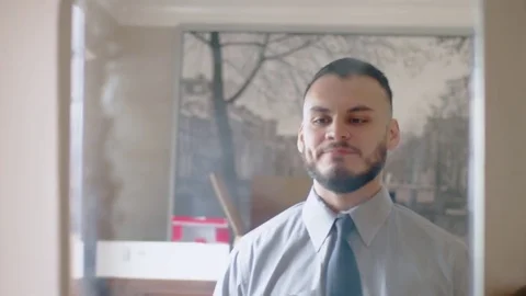 Young hispanic man steps up to mirror and practices handshake Stock Footage 84486577