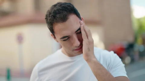 Young hispanic man stressed suffering for headache at street Video stock 230919473