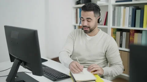 Young hispanic man student having video call at library university Stock Footage 232876197