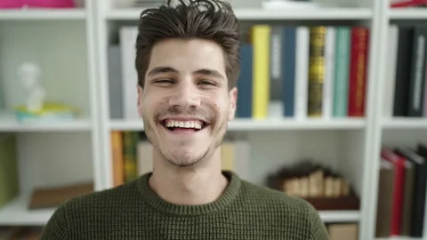 Young hispanic man student smiling confident sitting on table at library un.. Stock Footage 232875958