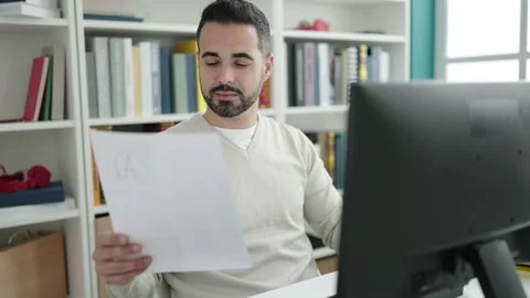 Young hispanic man student using computer reading document at library unive.. Stock Footage 232876222