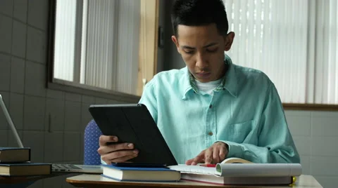 A young hispanic man studying with laptop and tablet Video stock 49663447