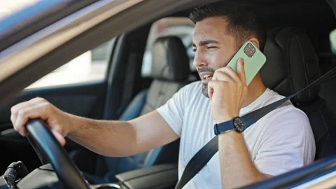 Young hispanic man talking on smartphone sitting on car with winner express.. Video stock 242328058