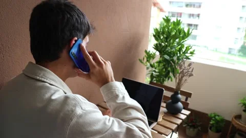 Young hispanic man teleworking and talking on his smartphone at home Stock Footage 319027689