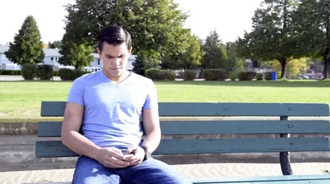 Young Hispanic man texting on phone at beach Stock Footage 42675552