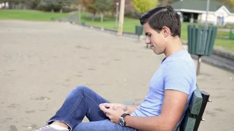 Young Hispanic man texting on phone at beach Stock Footage 42675606