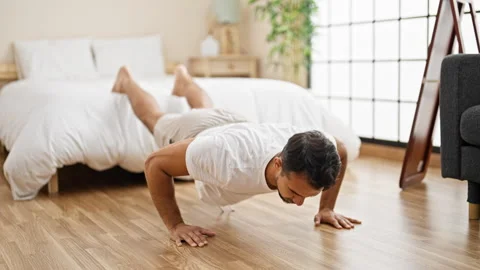 Young hispanic man training push up at bedroom Stock Footage 245030722