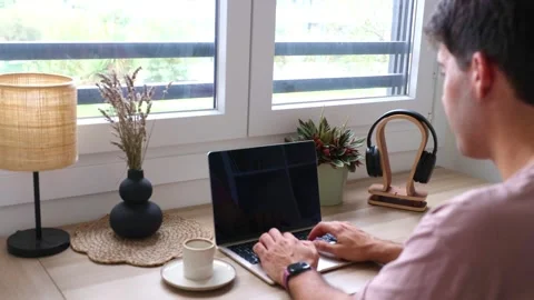Young Hispanic man typing on a laptop computer at home office Stock Footage 319027697