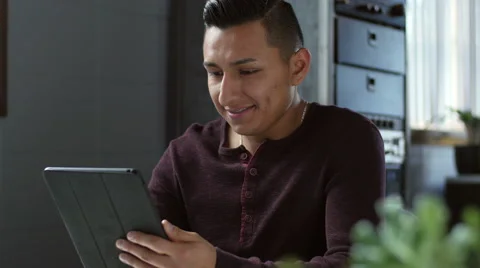 A young hispanic man using his tablet/pad Stock-Footage 58928926