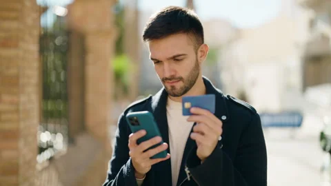Young hispanic man using smartphone and credit card at street Stock Footage 170655290