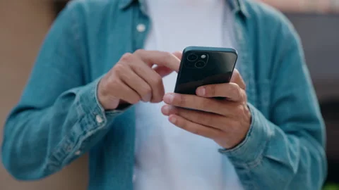 Young hispanic man using smartphone at street Stock Footage 220143898