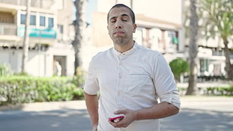 Young hispanic man using smartphone at park Video stock 247377292