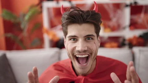 Young hispanic man wearing devil costume having halloween party at home Video stock 233416944