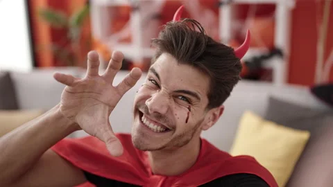 Young hispanic man wearing devil costume make selfie by camera at home Stock Footage 234652182