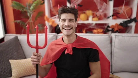 Young hispanic man wearing devil costume holding trident at home 動画素材 236801205