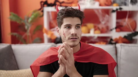 Young hispanic man wearing devil costume having halloween party at home Stock Footage 238619968