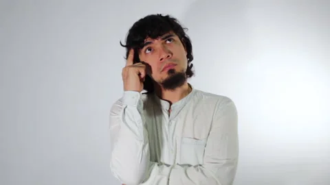 Young Hispanic man on a white background posing very thoughtful and concentrated Video stock 142846289
