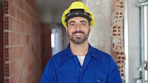 Young hispanic man worker wearing hardhat taking glasses off at constructio.. 스톡 동영상 247911183