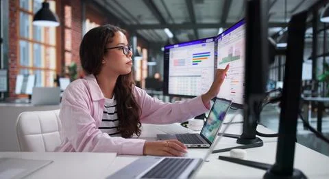 Young Hispanic Manager Plans Team Shifts Using Scheduling Software On Laptop. Stock Photos