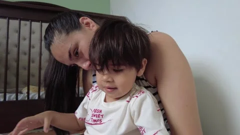 Young hispanic mom playing with her son and a toy Stock-Footage 243175629