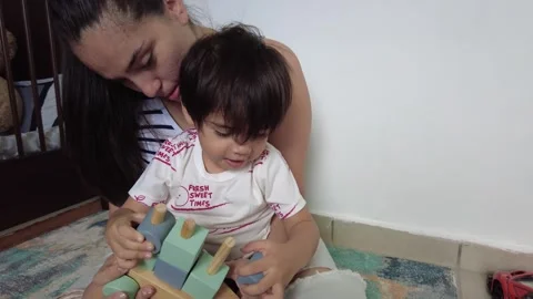 Young hispanic mom playing with her son and a toy Stock-Footage 243175657