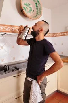Young hispanic self-sufficient man drinking directly from the coffee pot Stock Photos
