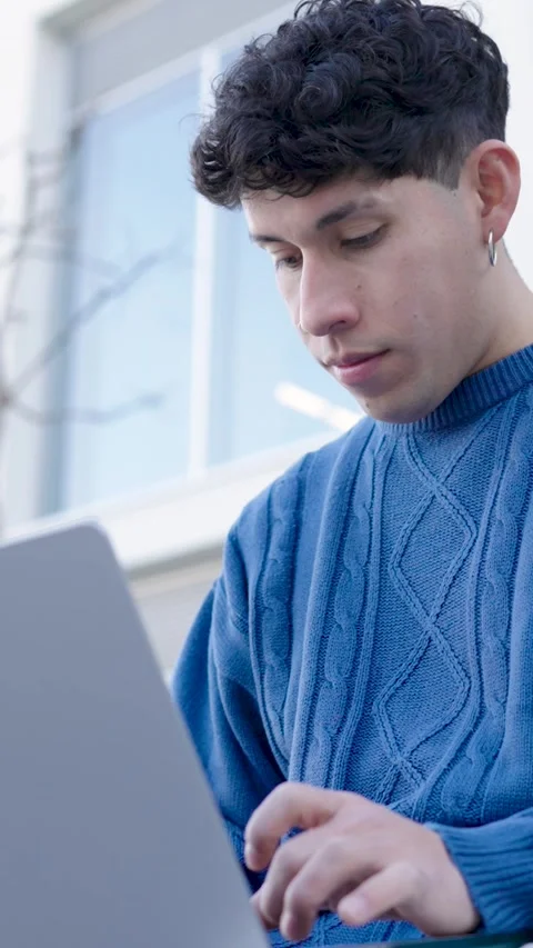 Young hispanic student working on laptop computer. Vertical Stock Footage 302730465