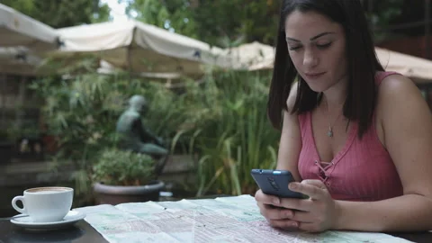 Young hispanic tourist looking a map while sitting on a cafe Stock Footage 159547119