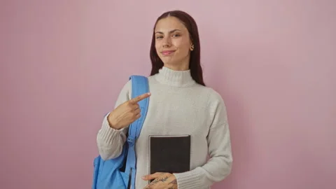 Young hispanic woman student in backpack holding book happily pointing with.. Stock Footage 281796383